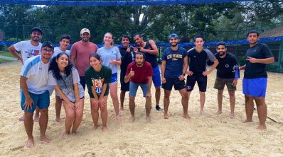 large group poses for photo on beach 