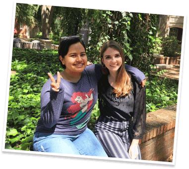 Two friends outdoors making peace sign