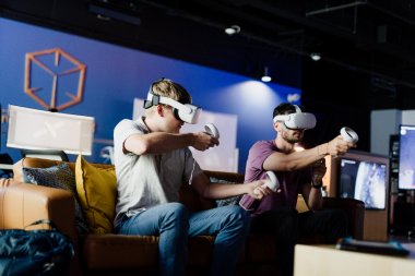 two men wearing vr video goggles